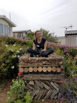 Photograph of our work experience candidate Laura, sitting on a bug hotel