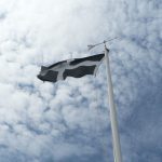 A picture of the cornish flag flying against the blue sky.