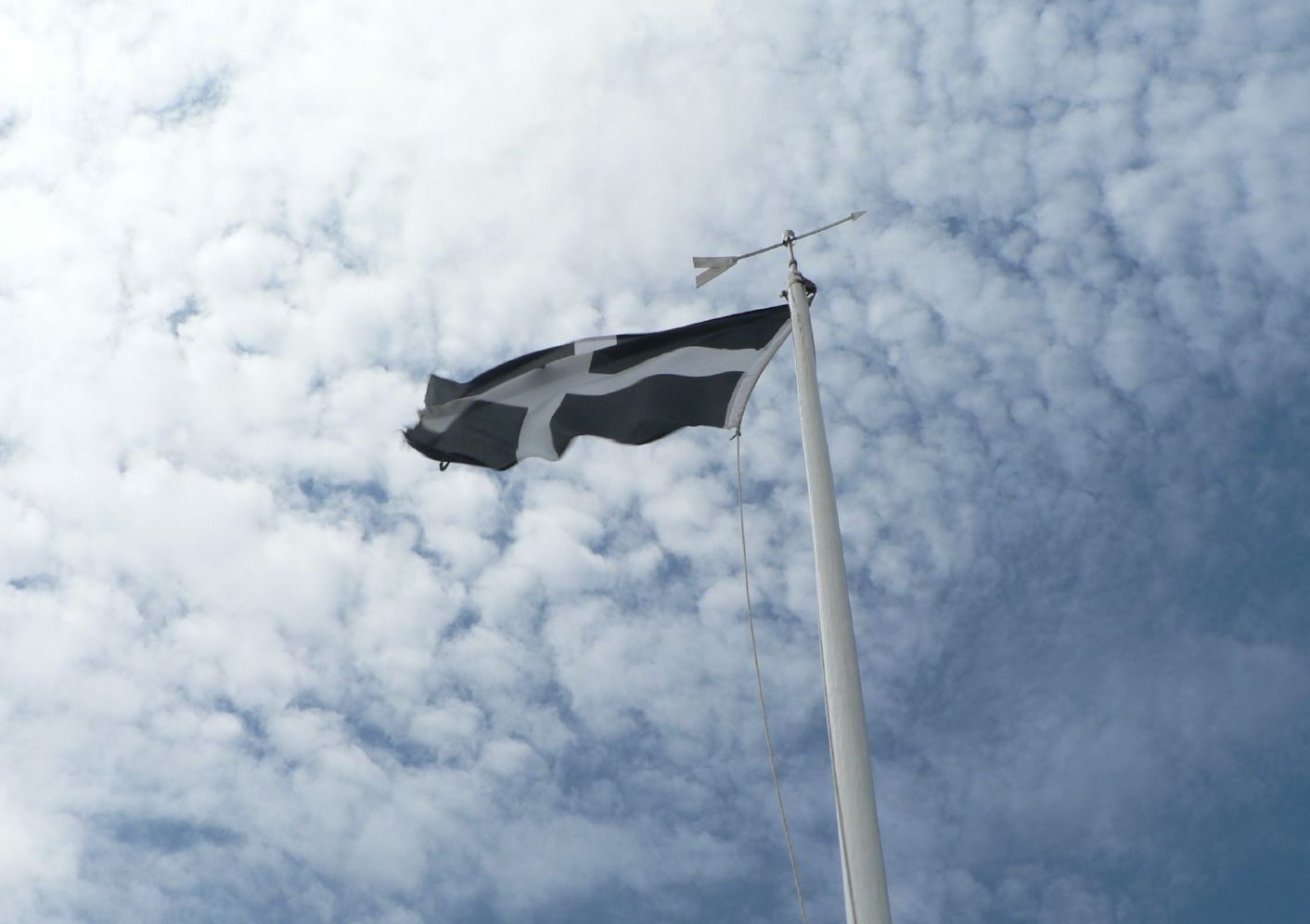 A picture of the cornish flag flying against the blue sky.